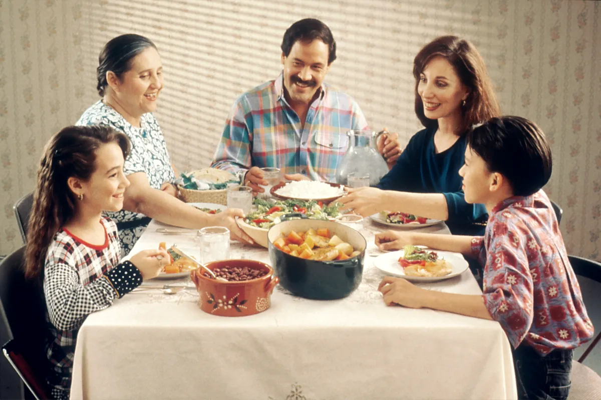 A family laughing and sharing dinner around the table